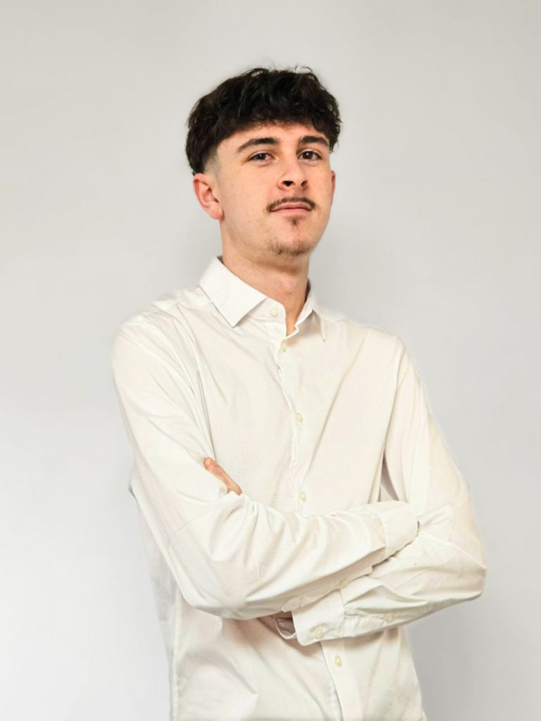 un homme en chemise blanche les bras croisés