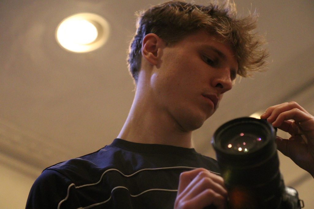 un homme regardant sa caméra dans ses mains