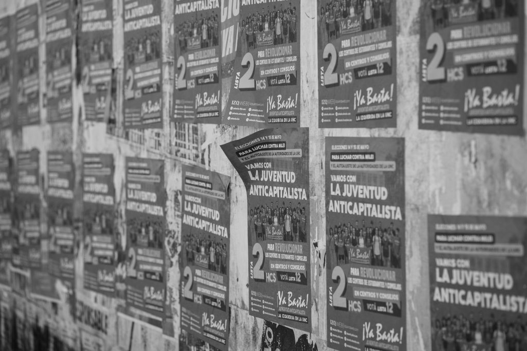 des affiches collées sur un mur en noir et blanc
