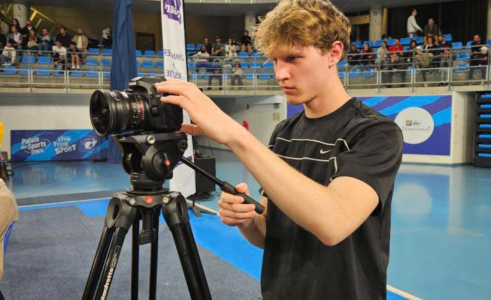 un homme filmant avec une caméra sur trépied